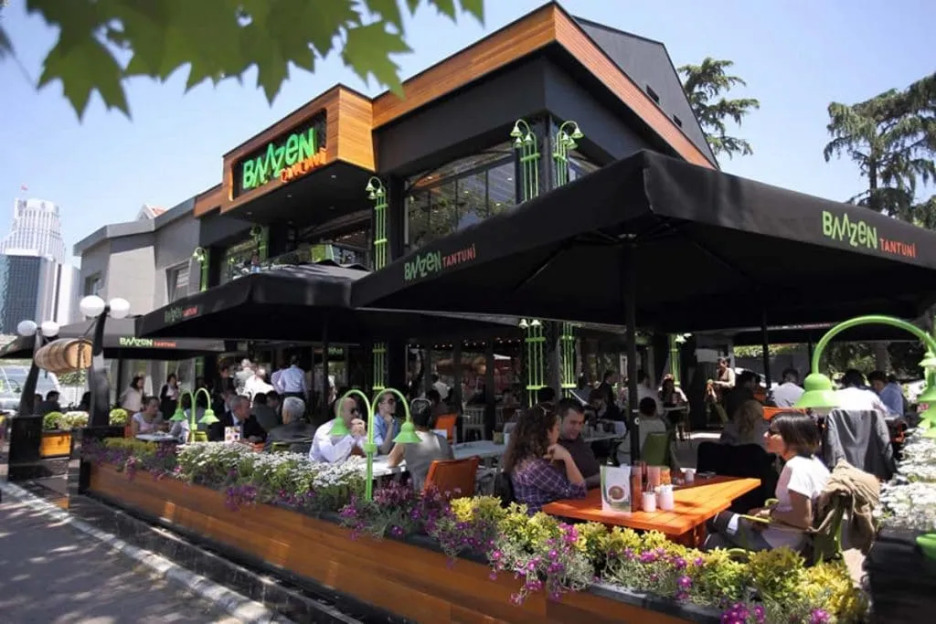 Baazen Tantuni's building in Levent with a terrace full of lunch guests under black umbrellas