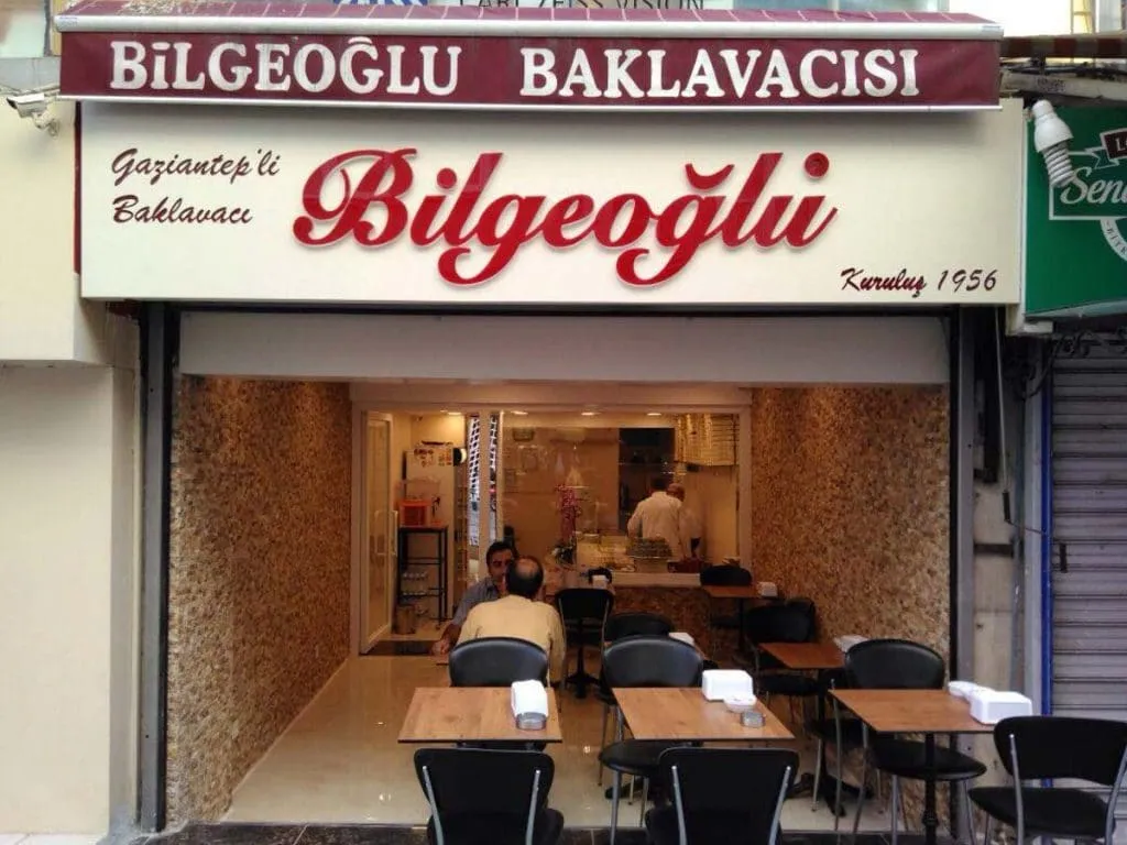 Bilgeoğlu Baklava storefront in Kadıköy, its sign reading Kuruluş 1956, with cafe tables inside
