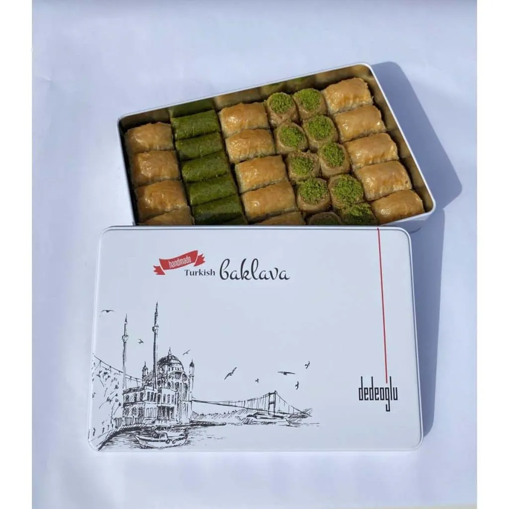 Open Dedeoğlu gift tin filled with rows of pistachio rolls and assorted baklava pieces