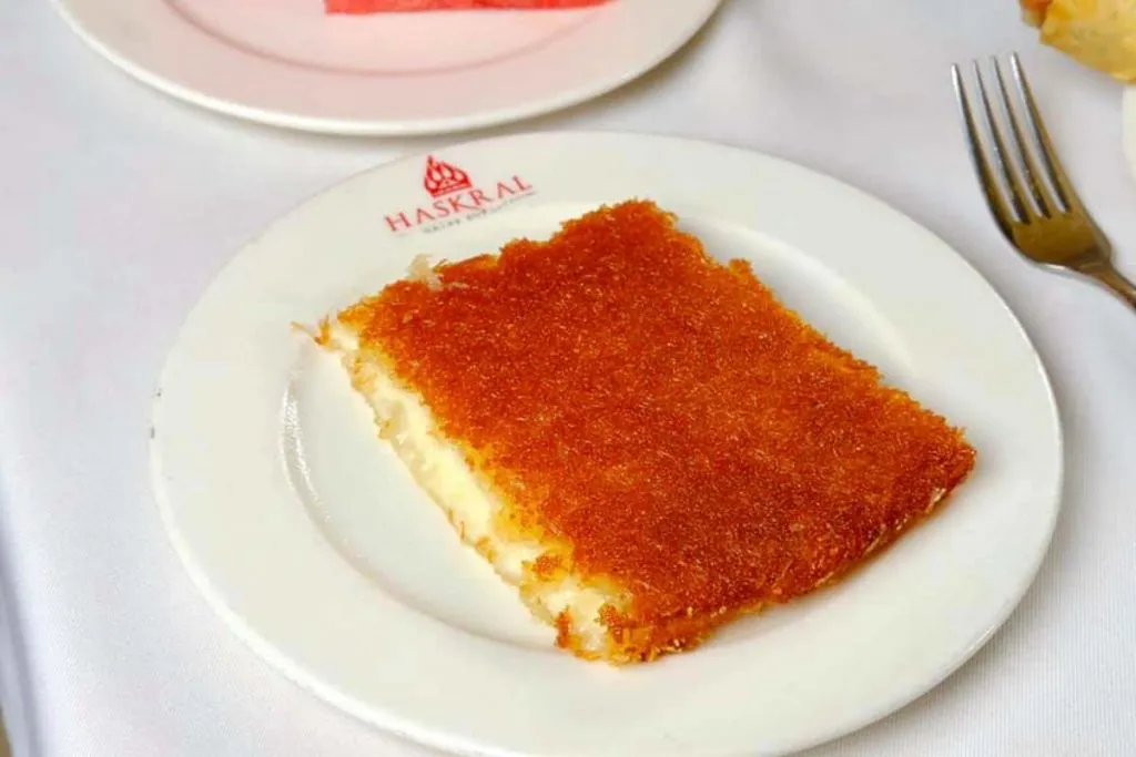 Rectangular künefe slice with a deep golden crust and a visible cheese layer on a Haskral logo plate