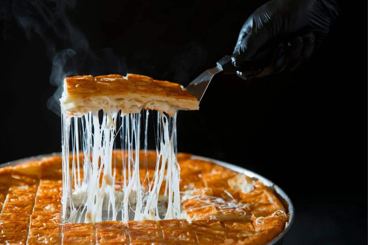 Fresh cheese börek cut into portions on a metal tray