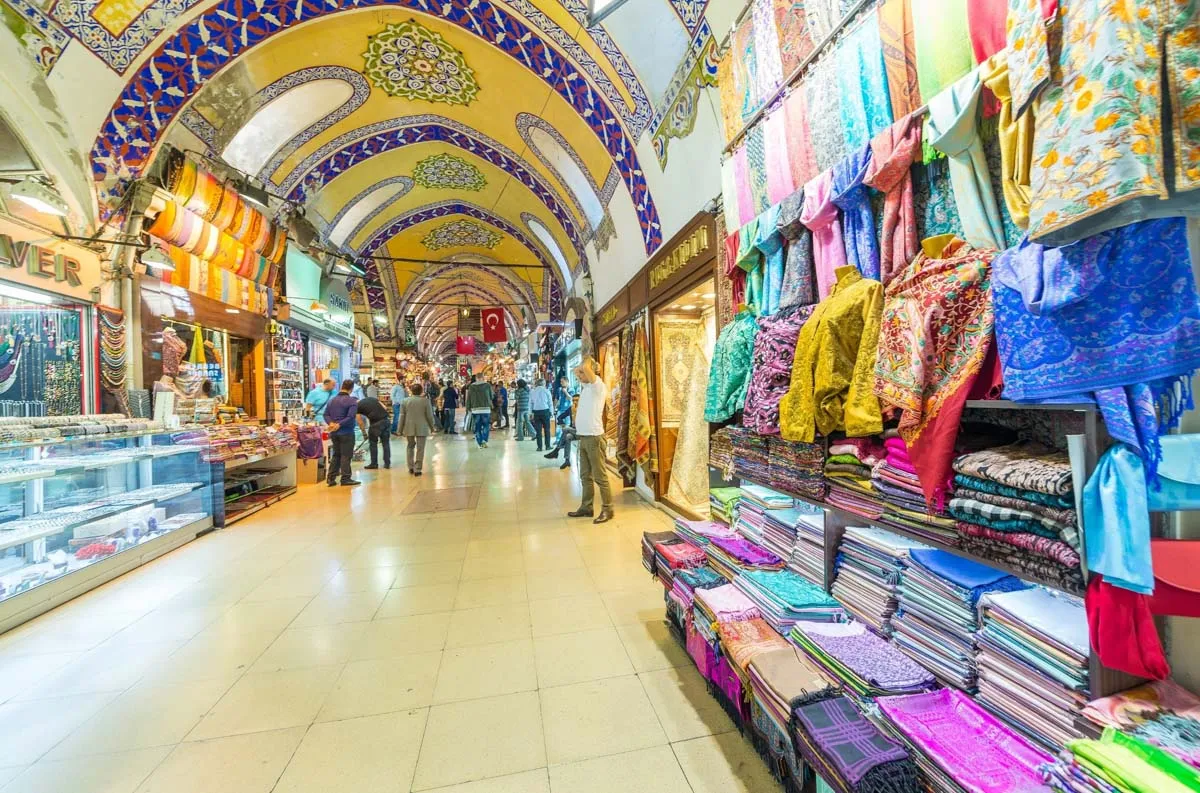 Shoppers walking through the vaulted, lamp-lit lanes of the Grand Bazaar in Istanbul