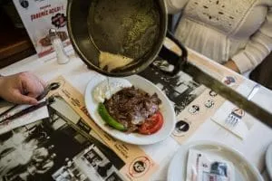 Iskender kebab: thin-cut doner meat over bread, topped with tomato sauce and yogurt