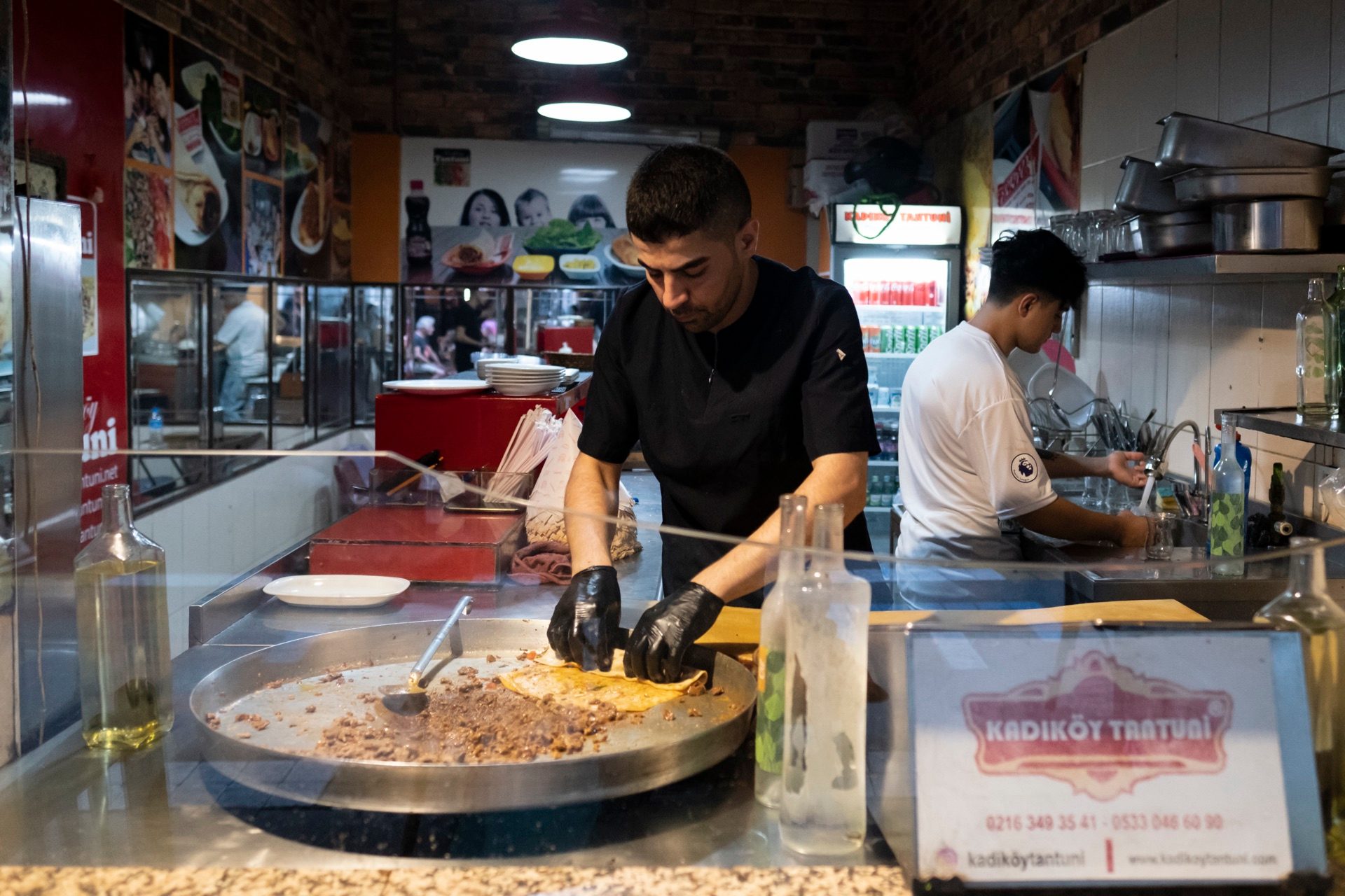 Cook griddling chopped meat at a Kadıköy street-food counter