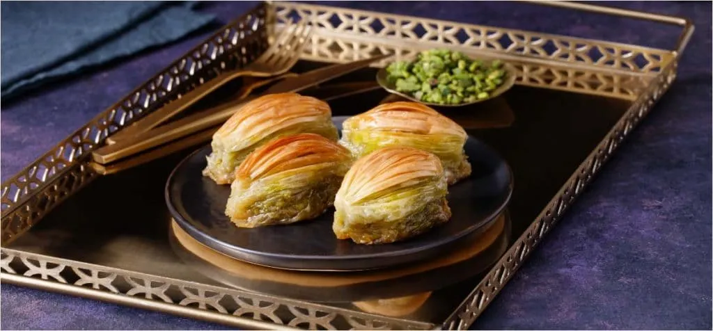 Counter case at Karaköy Güllüoğlu stacked with trays of pistachio and walnut baklava