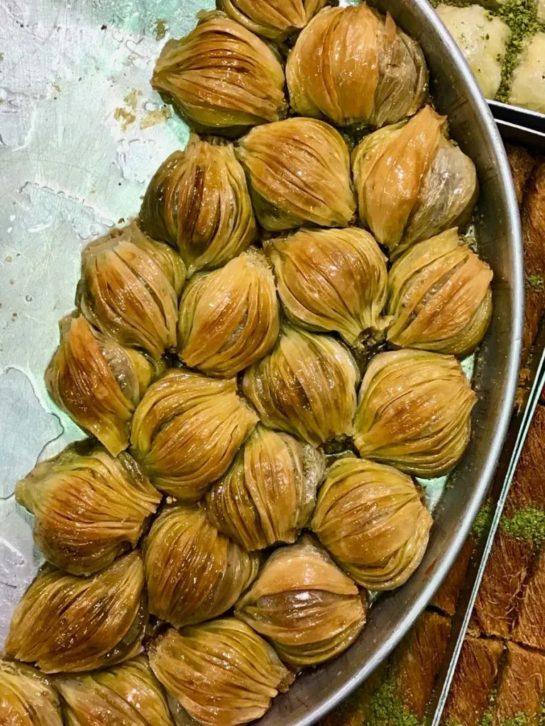 Round tray of midye baklava, mussel-shaped pieces with fanned phyllo layers