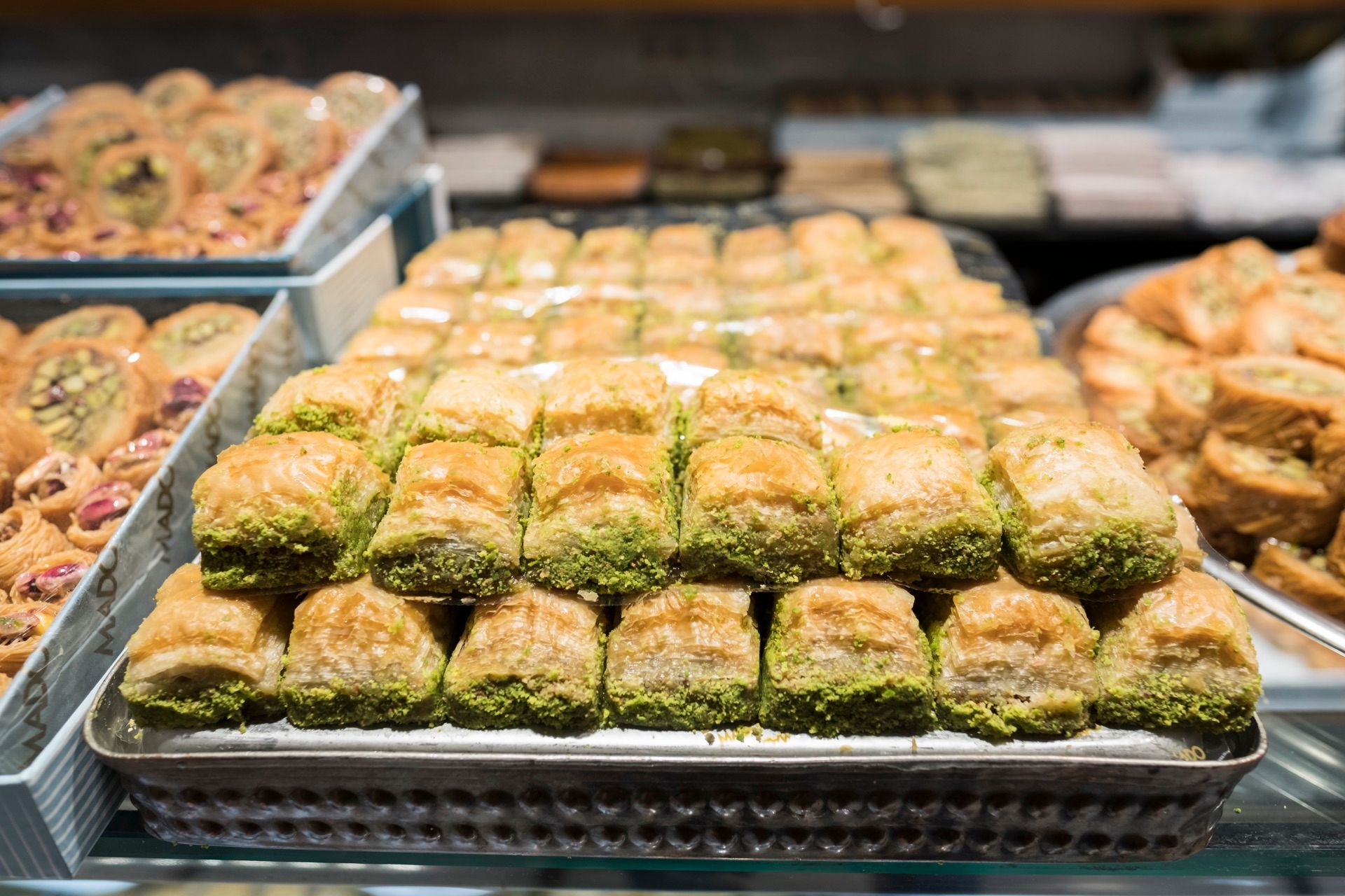 Trays of fresh pistachio baklava in a bakery display case in Istanbul