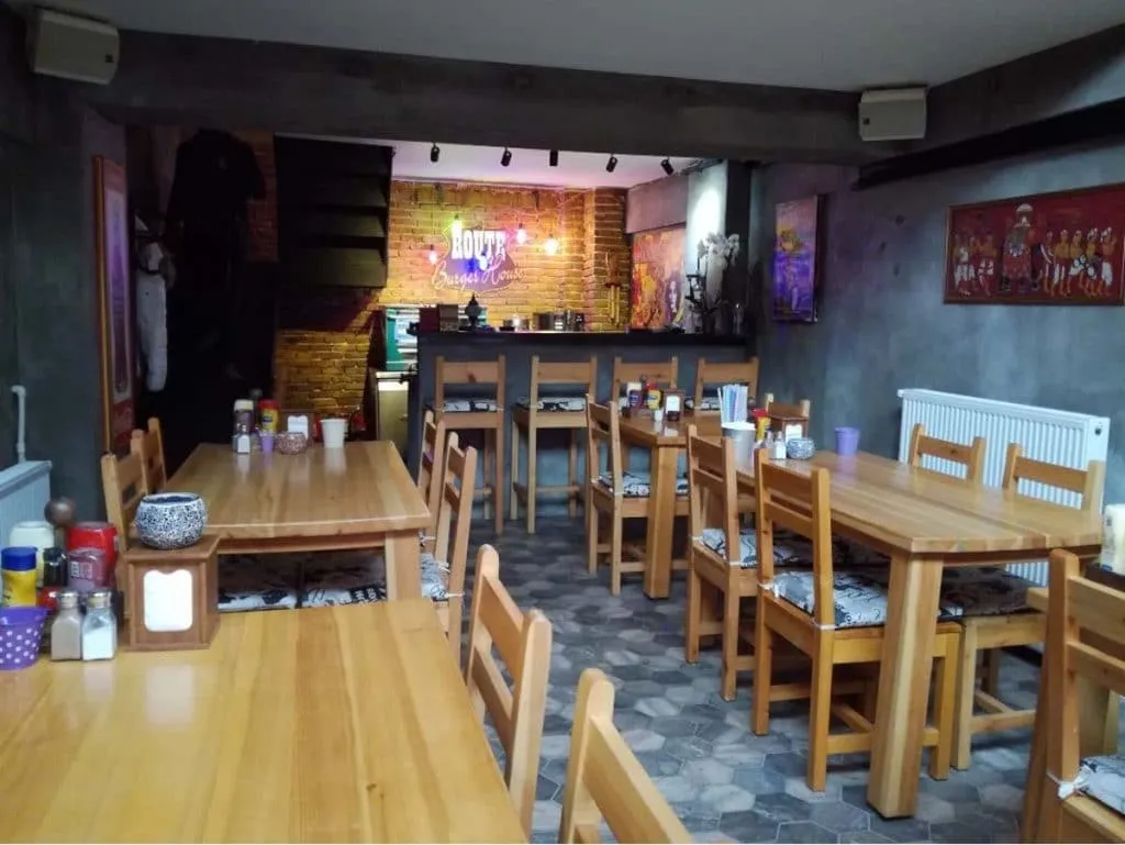 Wooden tables and a neon Route Burger House sign over the exposed-brick bar in the Karaköy dining room