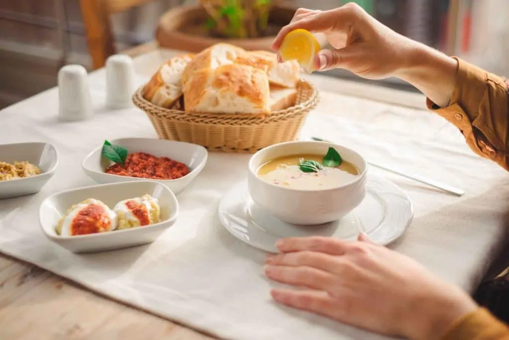 Squeezing lemon into Turkish lentil soup